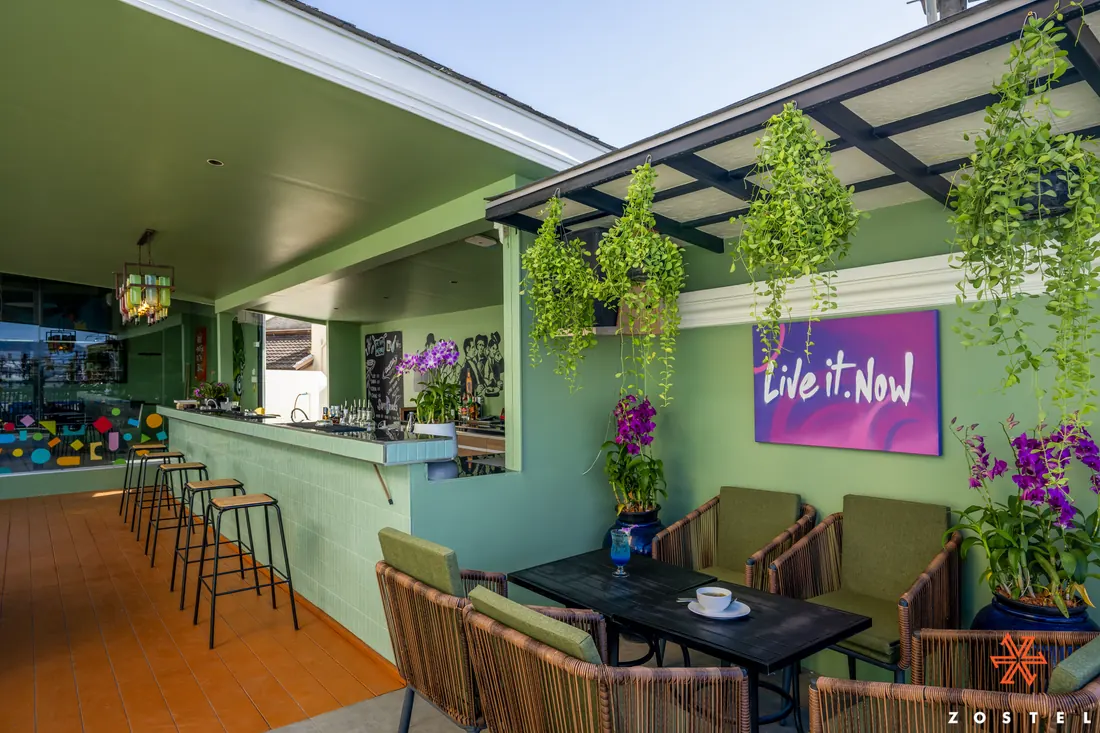 The indoor bar, plants overhead and a lit wall panel