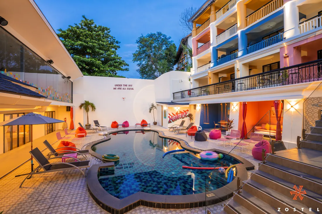 The pool courtyard at night, warm light on the balconies