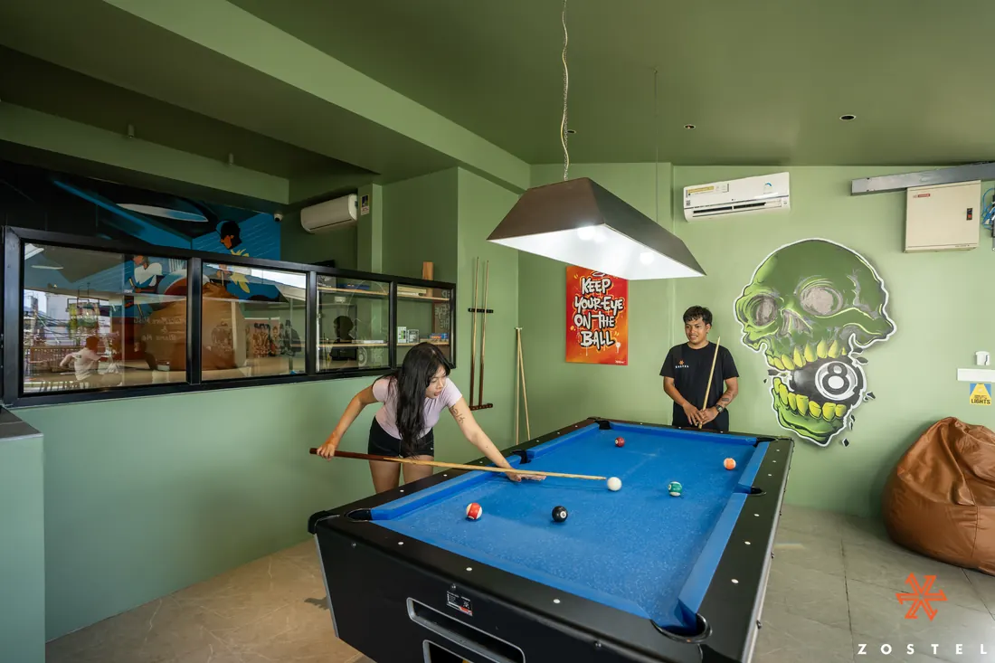 Games room with a pool table and a painted skull on the wall